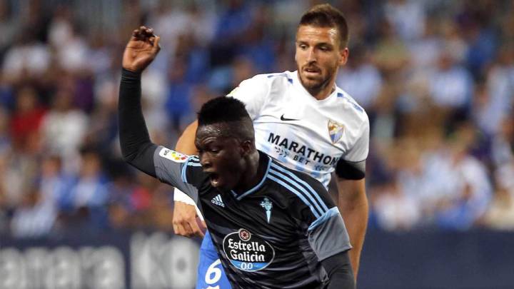 El centrocampista senegalés del Celta Pape Cheikh Diop cae ante los jugadores del Málaga el centrocampista Ignacio Camacho y el defensa uruguayo Federico Ricca.