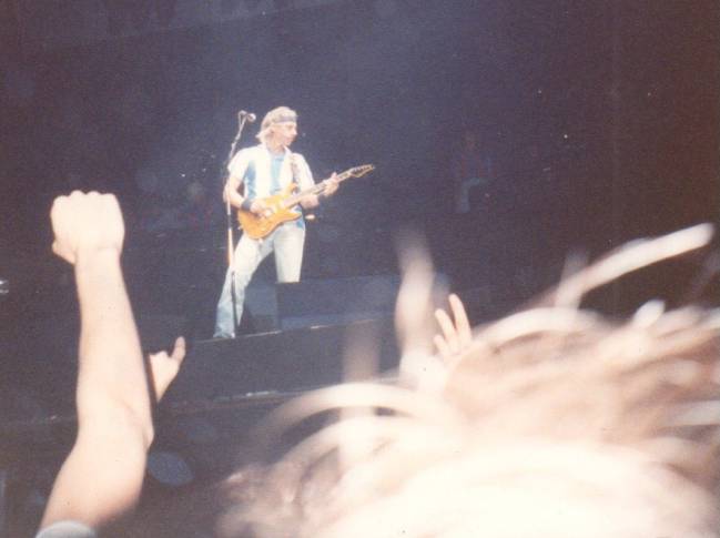 Mark Knopfler, tocando la guitarra como solo él sabe enfundado en la mítica Massana del Espanyol.
