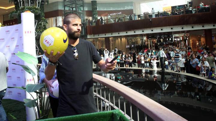 Spain's national team soccer player Gerard Pique signs his autograph on a soccer ball to the fans in a shopping centre in Doha, Qatar, July 5, 2017.