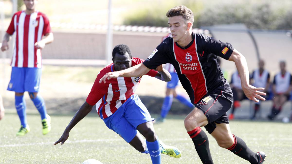 Cadete pugna por un balón en el Unión Adarve-Atlético B de Tercera jugado en el Vicente del Bosque.