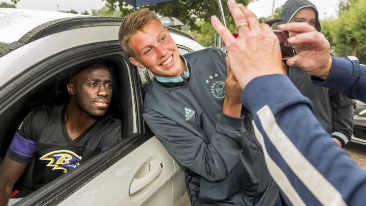 El defensa colombiano Davinson Sánchez posa para una foto con un aficionado a su salida del complejo de entrenamiento De Toekomst, en Amsterdam.