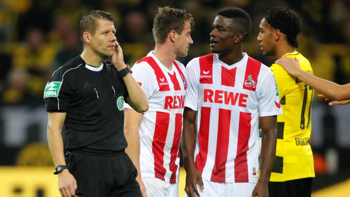 Referee Patrick Ittrich awaits instruction from the VAR to give the penalty to Dortmund against Cologne.