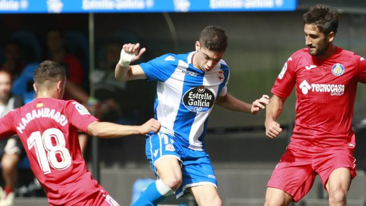 El centrocampista uruguayo del Deportivo Fede Valverde (c) disputa un balón con los jugadores del Getafe Mauro Arambarri (i) y Markel Bergara (d) durante el partido correspondiente a la séptima jornada de LaLiga Santander disputado hoy en el estadio de Riazor.