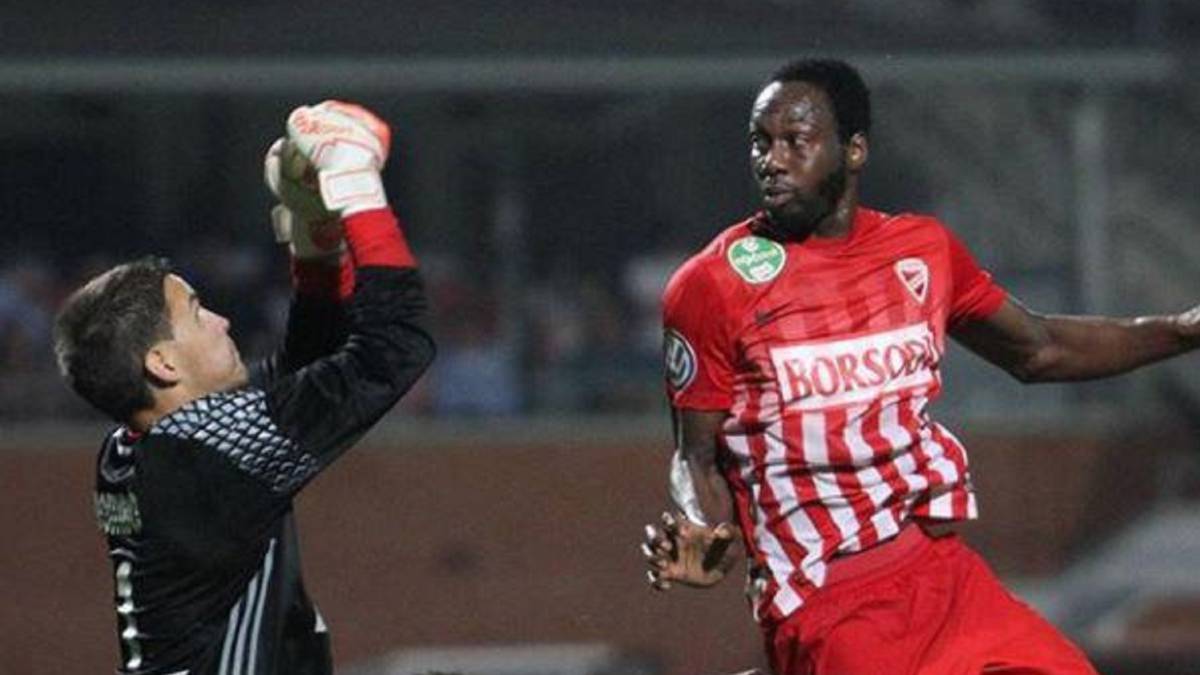 Georges Griffiths mientras disputa un balón con el arquero rival.