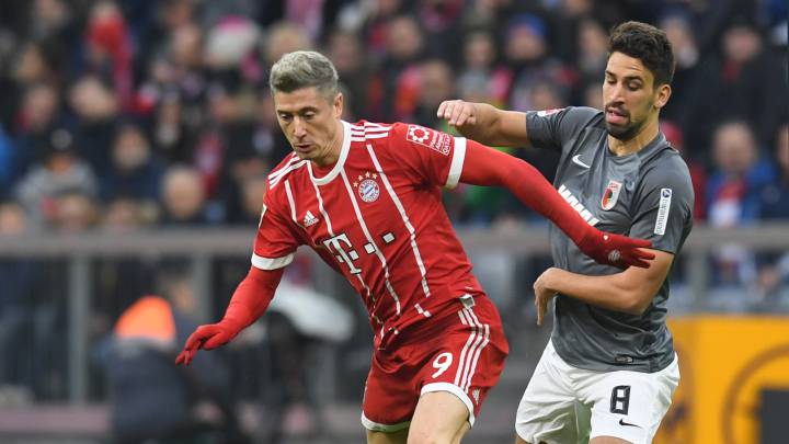 Rani Khedira, jugador del Augsburg de la Bundesliga, sidputando un balón con Robert Lewandowski.