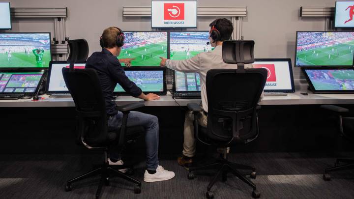 Imagen de un árbitro y un operado en el centro de videoasistencia de Colonia mientras revisna con el VAR algunos partidos de la Bundesliga.