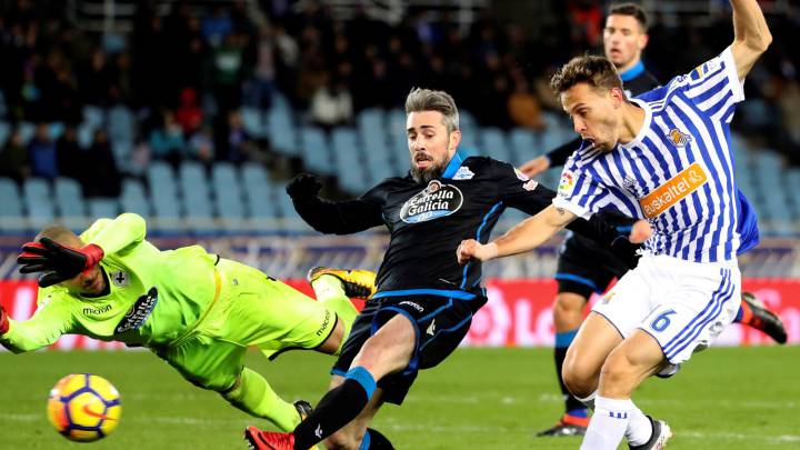 El centrocampista de la Real Sociedad Sergio Canales (d) chuta ante Luisinho (c) y el portero Rubén, ambos del Deportivo de la Coruña, durante el partido de Liga en Primera División disputado esta noche en el estadio de Anoeta, en San Sebastián