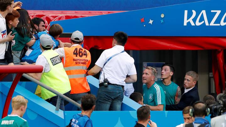 Mesut Özil, sujetado por un empleado de la Federación de Alemania tras la eliminación de la Mannschaft.