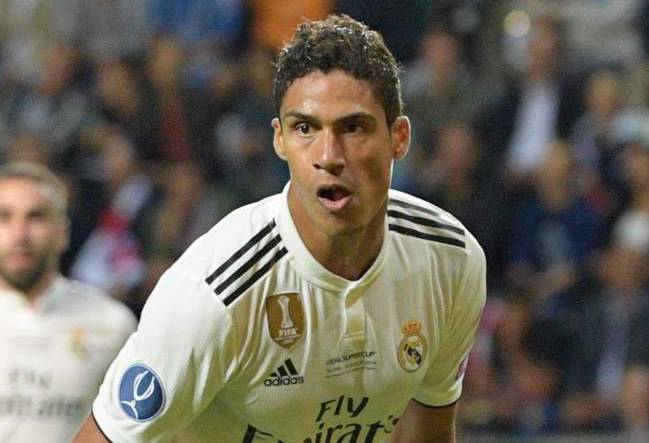 Rafael Varane, en segundo plano, contempla un remate de Diego Costa.