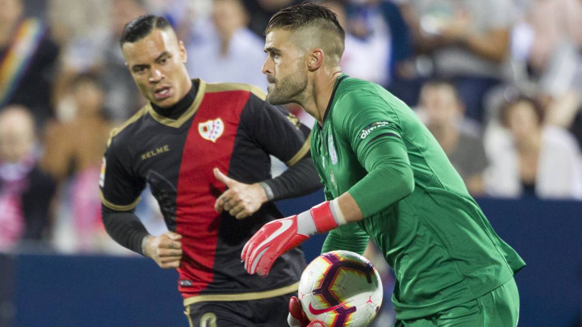 El meta del Leganés Cuéllar detiene el esférico ante la mirada del jugador del Rayo Vallecano De Tomás en el encuentro de LaLiga Santander entre el Leganés y el Rayo Vallecano disputado en Butarque.