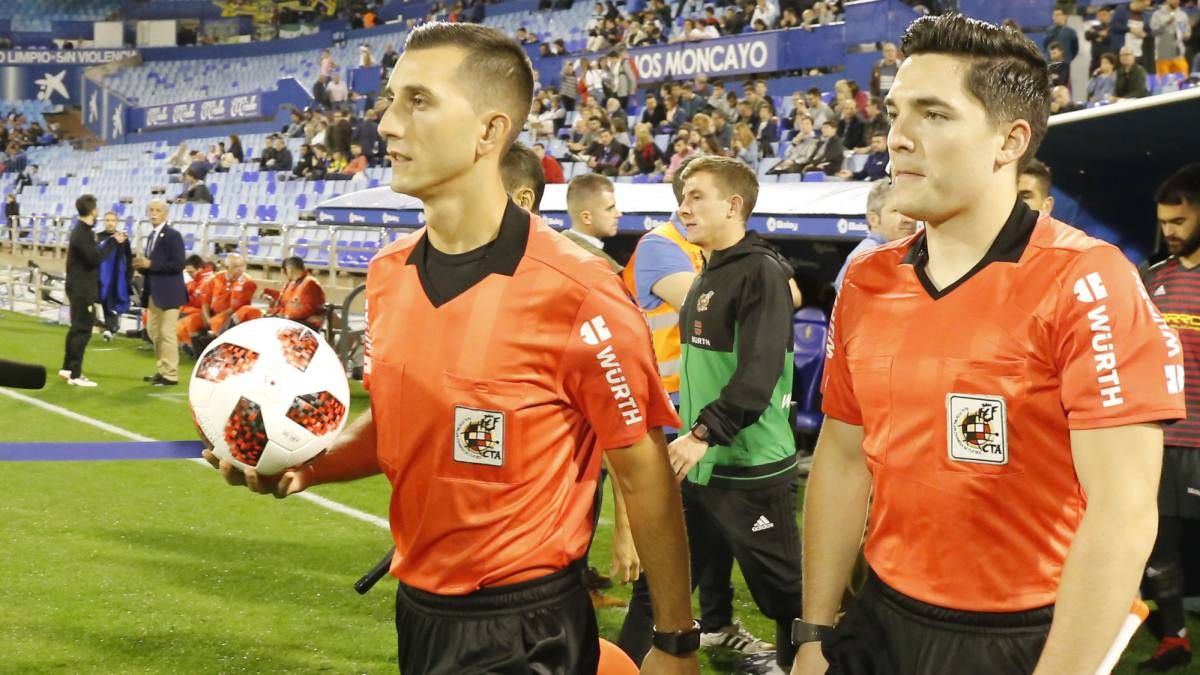 Los árbitros salen al campo durante un partido de Copa del Rey.