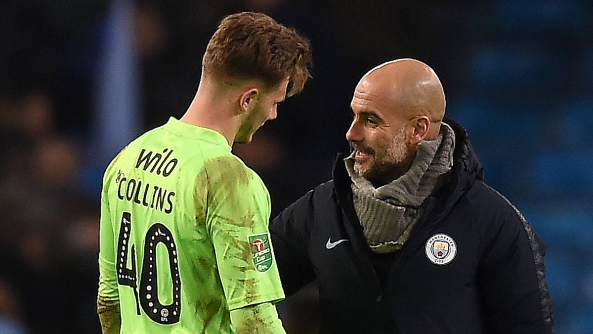 Pep Guardiola charla con el portero del Burton Albion, Bradley Collins, después de que este encajara nueve goles en el partido de la EFL Cup contra el Manchester City.