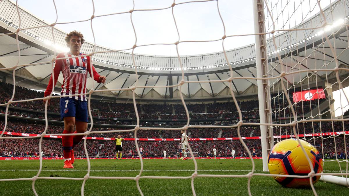 Griezmann acude a recoger un balón en la red en el derbi en el Wanda Metropolitano.