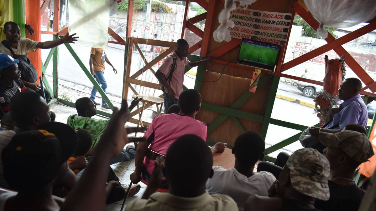 Aficionados siguen por televisión el Barcelona-Real Madrid de la Copa del Rey en Puerto Príncipe (Haití).