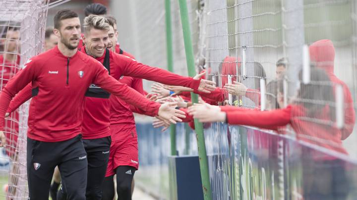 Los jugadores de Osasuna chocan las manos a los aficionados rojillos.