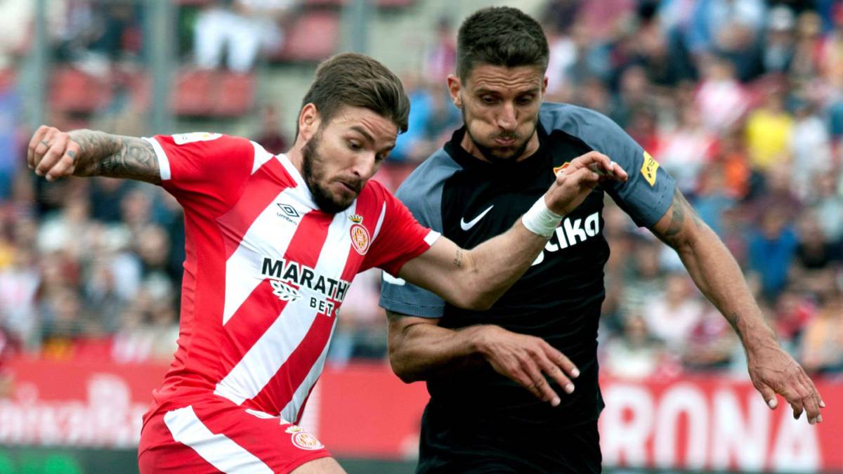 El jugador del Girona Cristian Portugués 'Portu', disputa un balón con el jugador portugués del Sevilla Daniel Carriço