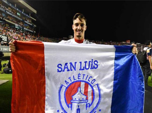 Ian González muestra orgulloso la bandera del Atlético de San Luis.