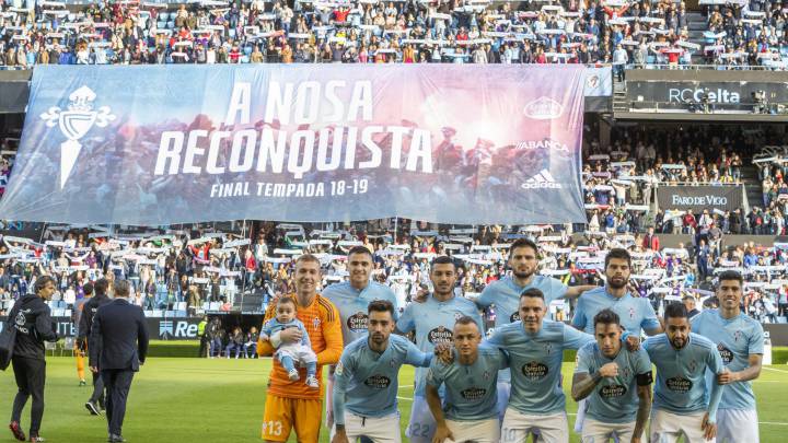 Los jugadores del Celta posan para los medios gráficos y en la grada los aficionados despliegan una pancarta gigante.