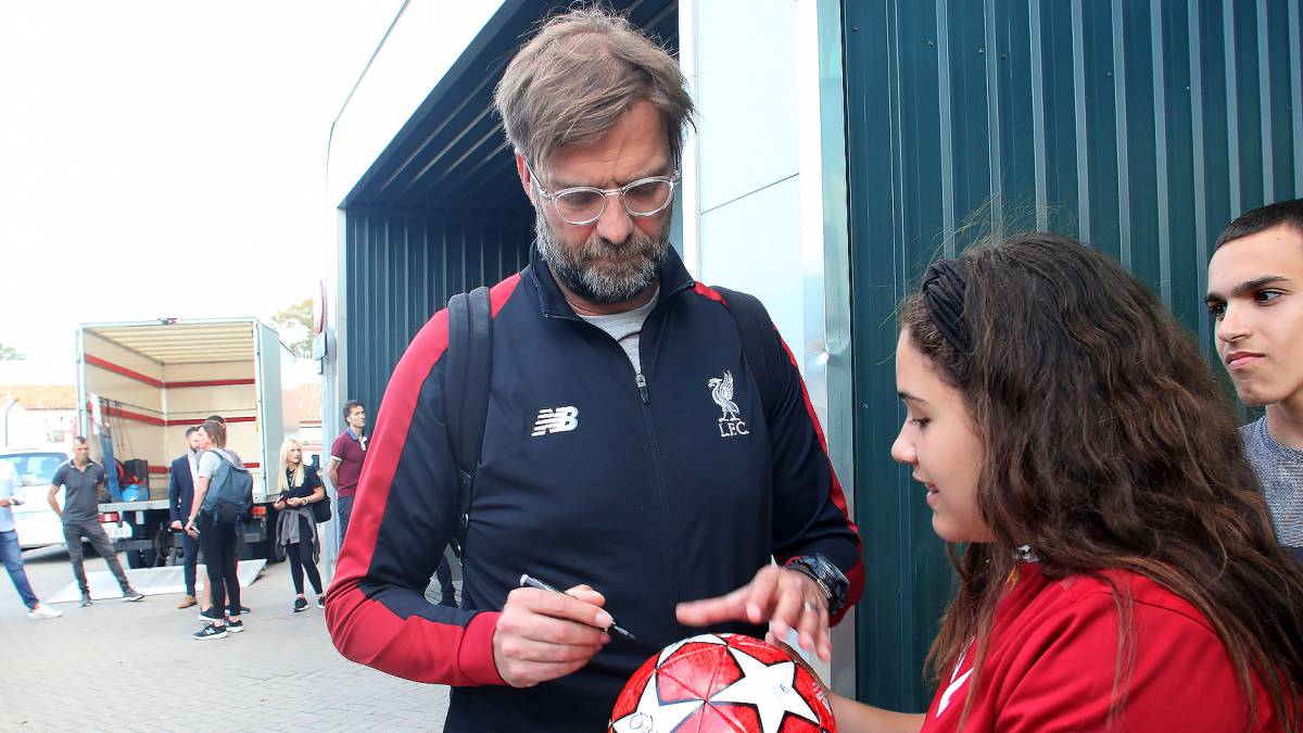 Jürgen Klopp firma una pelota para una aficionada en la llegada del Liverpool a Málaga.
