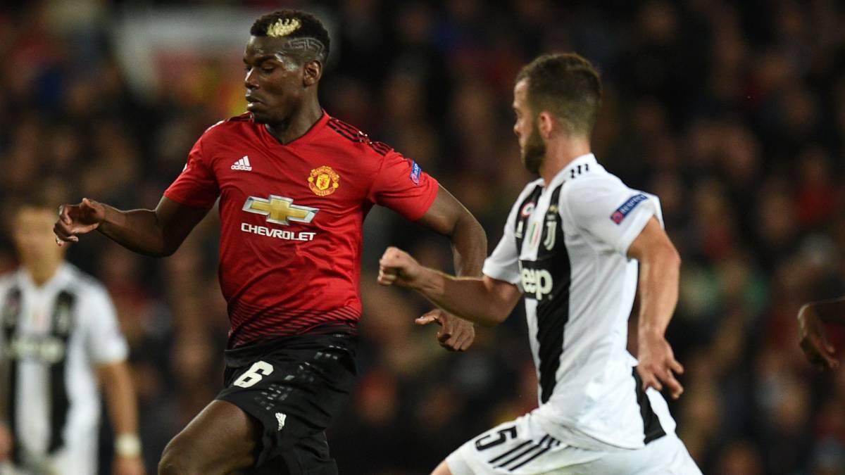 Paul Pogba disputa un balón ante Pjanic durante el Manchester United - Juventus de la Champions League.