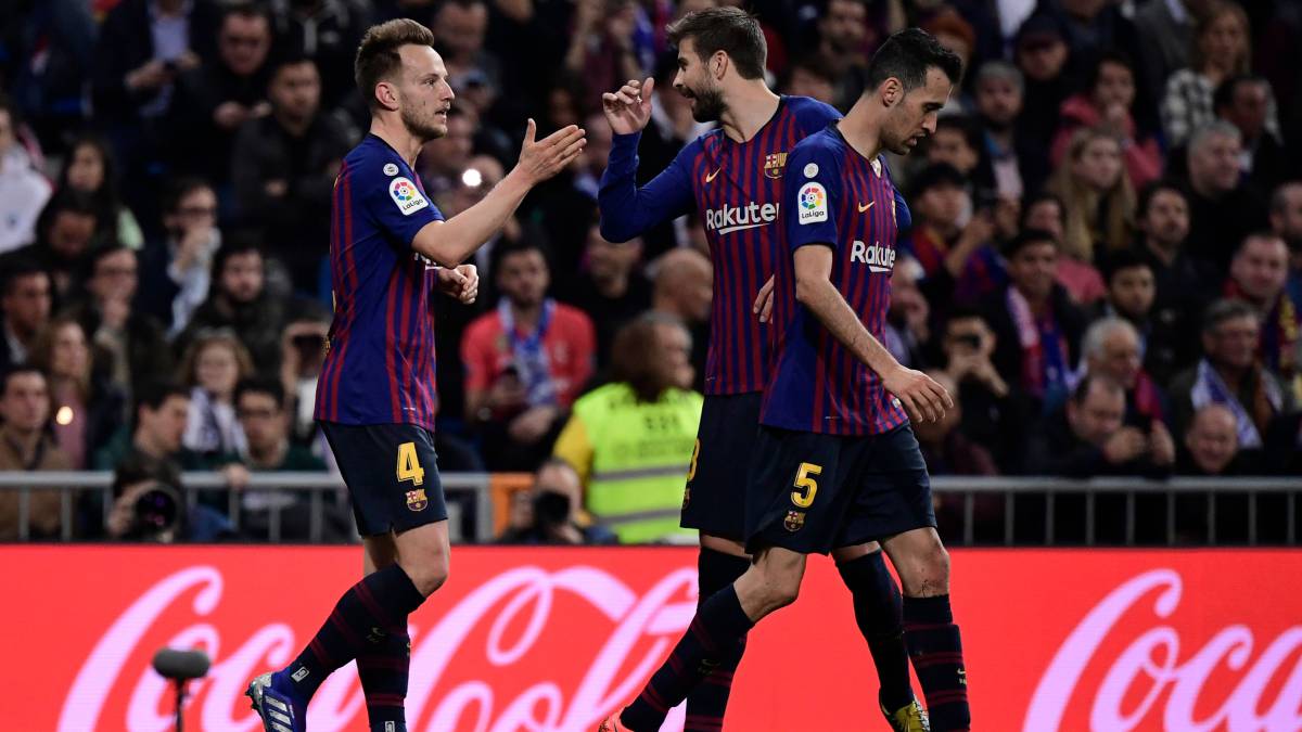 Ivan Rakitic, Gerard Piqué y Sergio Busquets celebran un gol durante el partido de Liga Santander entre Real Madrid y F.C. Barcelona.