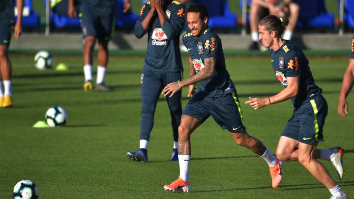 Neymar corriendo hacia un balón ante Filipe Luis durante un entrenamiento de la selección brasileña.