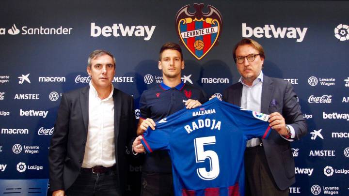Radoja (en el medio) posa con su nueva camiseta en la sala de prensa del Ciutat de Valencia acompañado de Manuel Salvador (izquierda) y Quico Catalán (derecha)