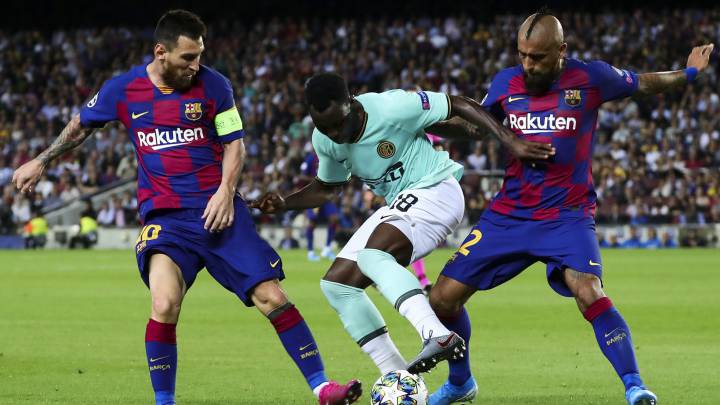 Arturo Vidal y Leo Messi pugnan por un balón con Kwadwo Asamoah durante el partido de la segunda jornada de fase de grupos de la Champions League entre F.C. Barcelona e Inter de Milán en el Camp Nou.