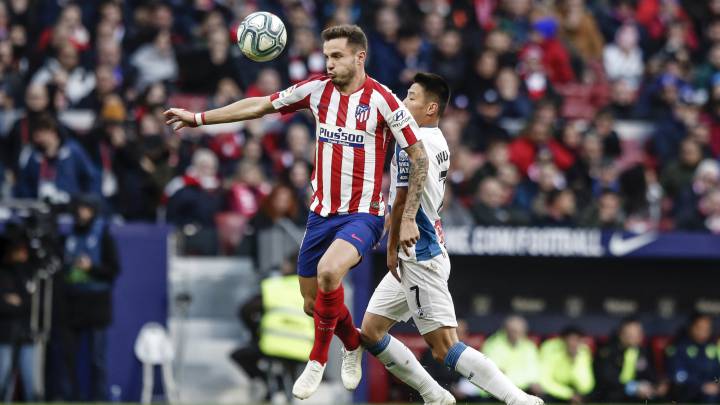 Saúl conduce el balón por delante de Wu Lei en el Atlético-Espanyol.