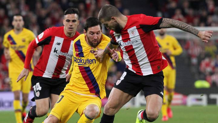 El defensa del Athletic Club de Bilbao Iñigo Martínez disputa un balón con Leo Messi.