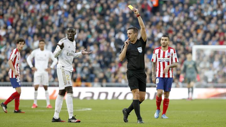 El colegiado Estrada Fernández amonesta a Mendy el pasado 1 de febrero en el derbi entre el Real Madrid y el Atlético.