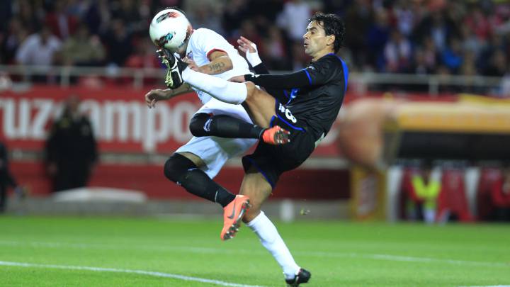 Míchel controla un balón que se disputa con Reyes.