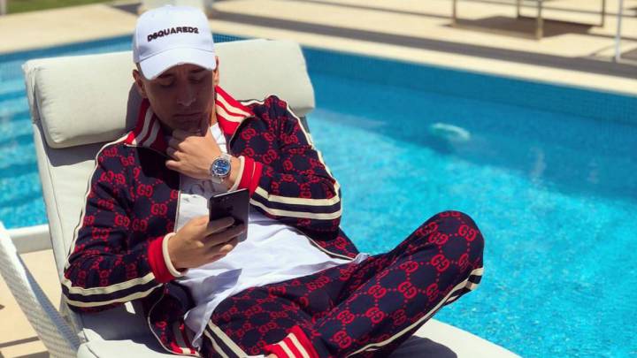 Emre Mor consulta su teléfono móvil sentado en una tumbona al lado de una piscina.