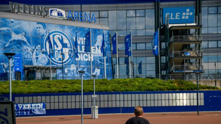 A man stands outside the arena and the training ground pof the Bundesliga football club Schalke 04 in Gelsenkirchen, western Germany, where fans demonstrate to protest against the club's management on June 27, 2020, at the same time as the kick-off of the last match of the season against Freiburg. - The demonstration took place under the motto "Schalke is not an abattoir - against the dismantling of our club", as lockdowns in Guetersloh and neighbouring Warendorf in western Germany came after a coronavirus outbreak at a slaughterhouse of Toennies company. (Photo by SASCHA SCHUERMANN / AFP)