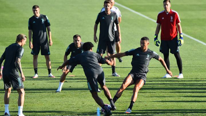 Cristiano y Cuadrado pugnan por un balón durante el entrenamiento de la Juventus, ayer.