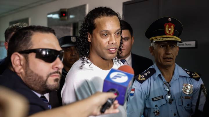 AME1695. ASUNCIÓN (PARAGUAY), 06/03/2020.- Ronaldo de Assis Moreira, Ronaldinho, llega este viernes al Palacio de Justicia para comparecer ante el juez Mirko Valinotti, en Asunción (Paraguay). El exinternacional brasileño Ronaldinho Gaúcho y su hermano Roberto comparecieron este viernes ante el juez que decidirá si les beneficia con una salida procesal que les desvincule de la causa abierta tras ingresar en Paraguay con pasaportes falsos. El recurso a esa "salida procesal abreviada" fue concedido el jueves por la Fiscalía a los dos hermanos y se debió a que ambos aportaron "datos relevantes" a la investigación, según explicó anoche el fiscal de la causa, Federico Delfino. EFE/Nathalia Aguilar