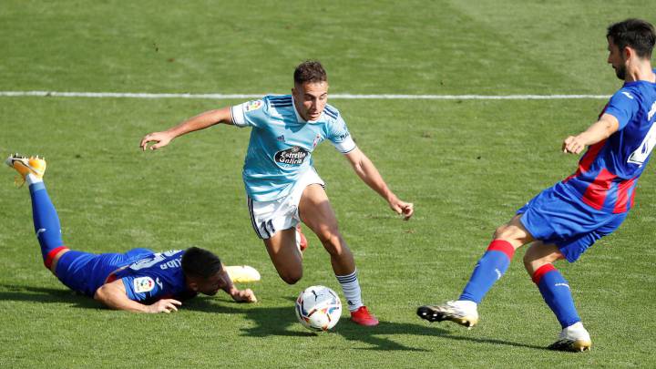 Los jugadores del Eibar, el polaco Damian Kadzior y el portugués Paulo Oliveira intentan arrebatar el balón a Emre Mor, delantero turco del Celta de Vigo, durante el partido de la primera jornada de la LaLiga Santander que disputan este sábado en el estadio de Ipurúa de Eibar (Guipúzcoa).