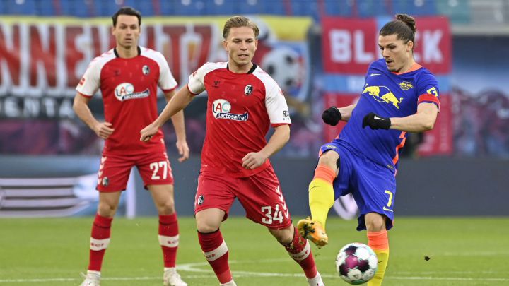 Freiburg's German midfielder Lino Tempelmann (C) and Leipzig's Austrian midfielder Marcel Sabitzer (R) vie for the ball during the German first division Bundesliga football match between RB Leipzig and SC Freiburg in the Red Bull arena in Leipzig, eastern Germany, on November 7, 2020. (Photo by John MACDOUGALL / AFP) / DFL REGULATIONS PROHIBIT ANY USE OF PHOTOGRAPHS AS IMAGE SEQUENCES AND/OR QUASI-VIDEO