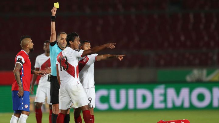 El árbitro Esteban Ostojich sanciona con tarjeta amarilla a Renato Tapia en el partido que disputó Perú ante Chile