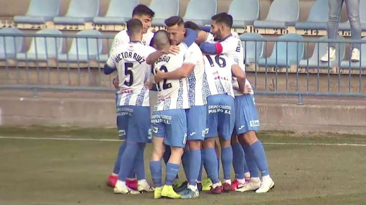 La piña de los jugadores del Talavera para felicitar a Pablo Monroy por su gol, que dio la victoria a los blanquiazules contra el Villanovense.