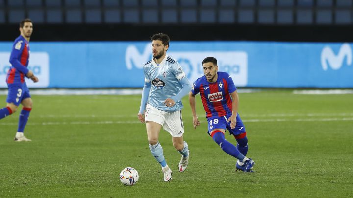 Okay Yokuslu conduce el balón delante de Recio durante el partido entre el Celta y el Eibar.