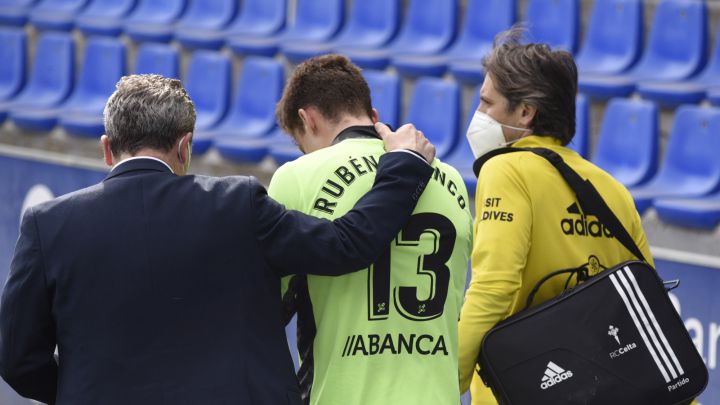 Rubén Blanco se retira del terreno de juego de El Alcoraz acompañado por el doctor Cota y el fisioterapeuta Ernesto Vieito