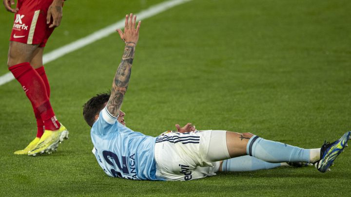 Santi Mina pide penalti desde el suelo tras ser derribado por Jules Koundé en el partido del Celta contra el Sevilla en Balaídos.