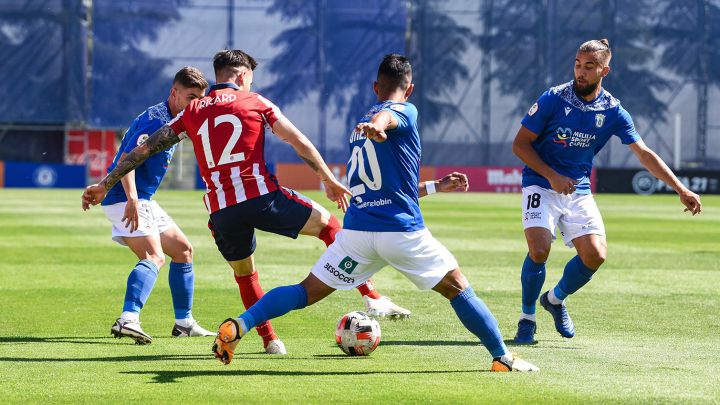 Ricard, del Atlético B, rodeado de jugadores del Melilla.