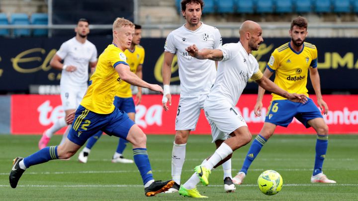 CÁDRIZ, 08/05/2021. El centrocampista de la SD Huesca, Mikel Rico (d), conduce el balón ante el centrocampista danés del Cádiz, Jens Jonsson, durante el encuentro correspondiente a la jornada 35 de primera división disputado hoy sábado en el estadio Ramón de Carranza, en Cádiz. EFE/Román Ríos.