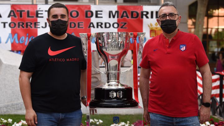 Miembros de la peña Atlético de Madrid de Torrejón de Ardoz con el trofeo de campeones.