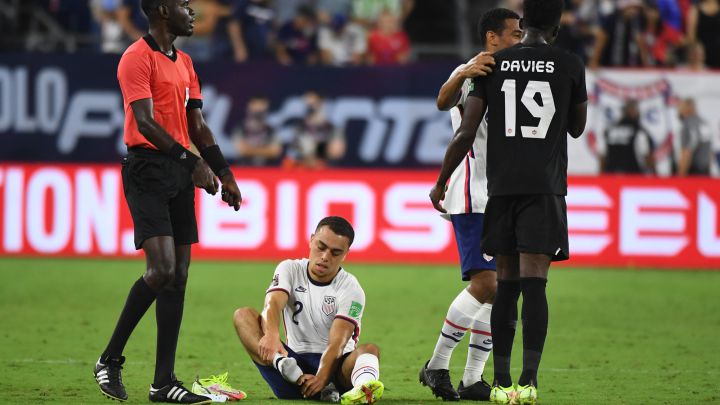 Sergiño Dest se duele de un golpe en el tobillo durante un partido con Estados unidos frente a Canadá.