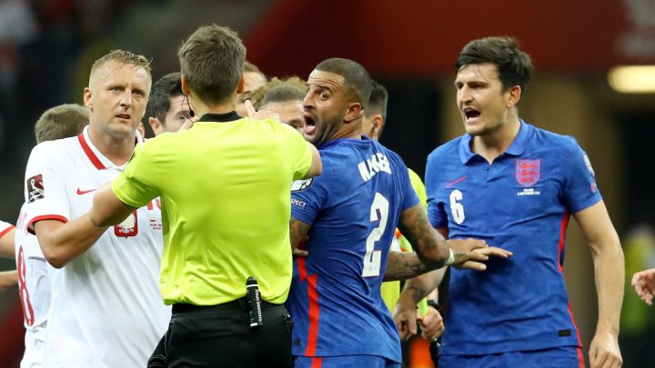 Kamil Glik, jugador polaco, y Kyle Walker, jugador inglés, protestan al árbitro durante un momento del partido de clasificación para el Mundial de Qatar 2022.