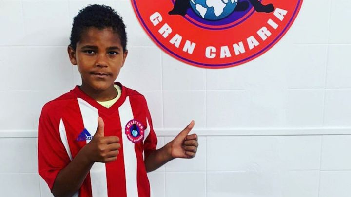 Daniel Santos Ruiz, jugador de 9 años del Atlético Gran Canaria, posa con la camiseta y el escudo del club.