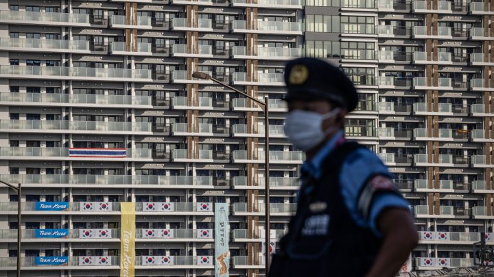 Un policía con mascarilla vigila las instalaciones de la Villa Olímpica de los Juegos Olímpicos de Tokio 2020.